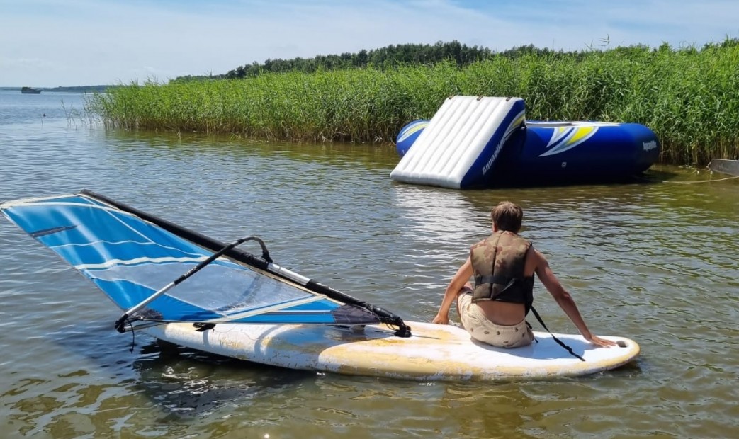 Chłopak na jeziorze zajęcia z windsurfingu