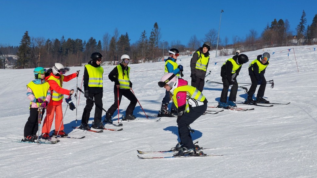 Dzieci uczące się jeździć na nartach